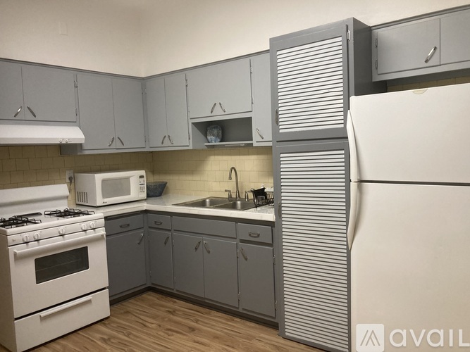 A kitchen with a white stove and a white microwave.