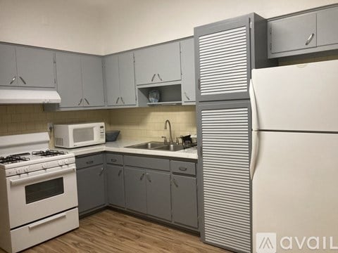 A kitchen with a white stove and a white microwave.