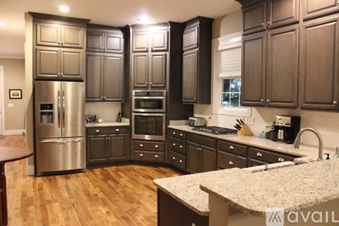 A kitchen with wooden cabinets and a granite counter top.