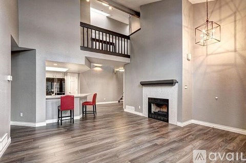 A living room with a fireplace and a dining table with chairs.