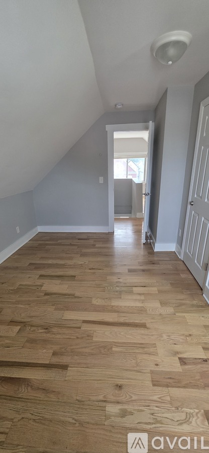 A room with wooden flooring and a white door.