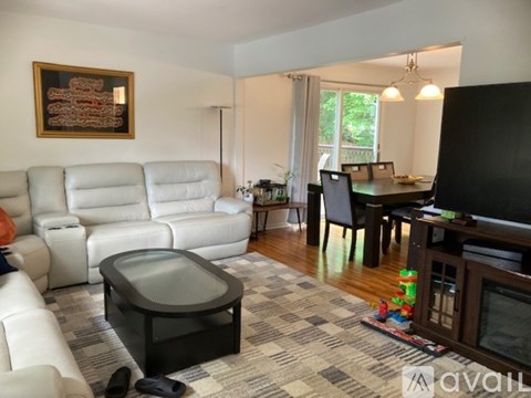 A living room with a white couch and a black coffee table.