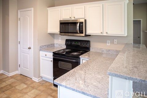 A kitchen with a black microwave above the stove.