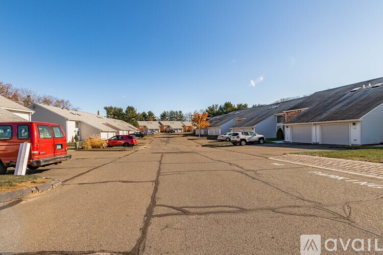 A parking lot with cars and buildings on either side.