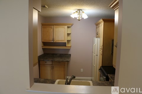 A kitchen with wooden cabinets and a granite countertop.