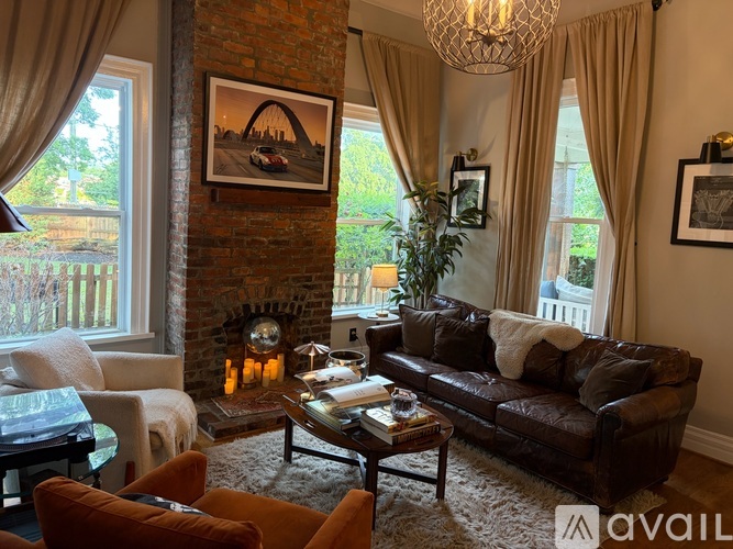 A living room with a fireplace and a painting on the wall.