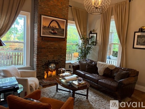 A living room with a fireplace and a painting on the wall.
