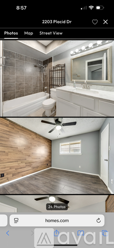 A bathroom with a tiled shower and a wooden floor.