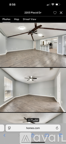 A mobile phone displaying a real estate app with a photo of an empty room.