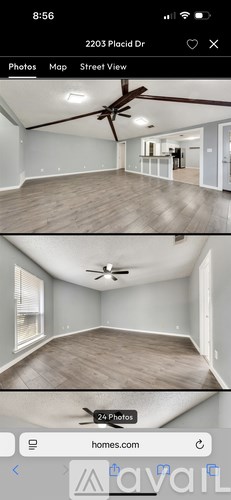 A mobile phone displaying a real estate app with a photo of an empty room.