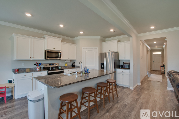 A kitchen with white cabinets and a granite countertop.