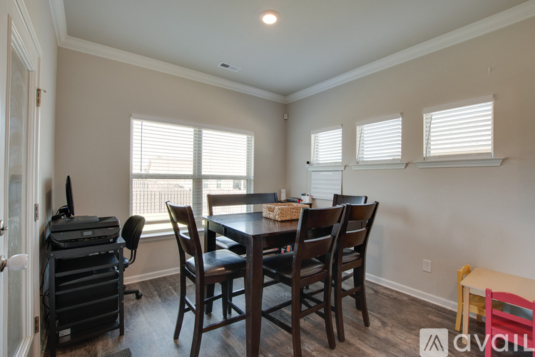 A dining room with a table and chairs.