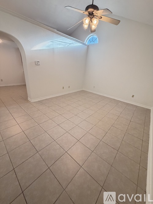 A room with a ceiling fan and tiled flooring.