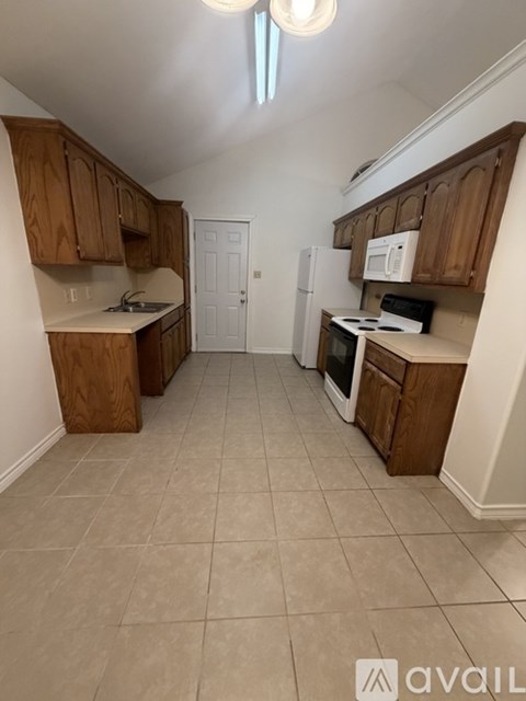 A kitchen with wooden cabinets and a white refrigerator.
