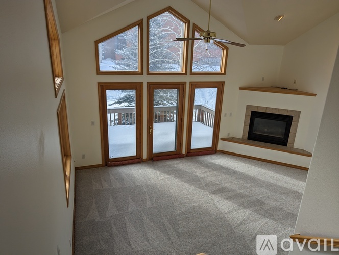 A living room with a fireplace and a large window.