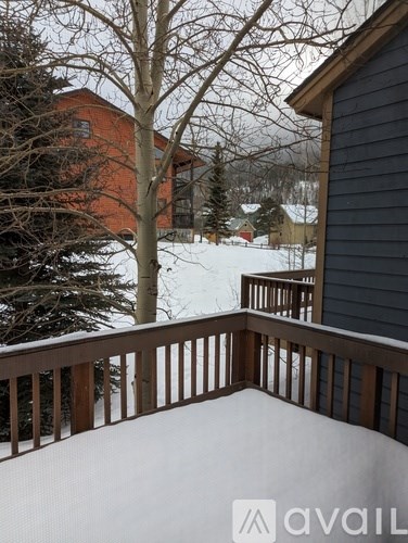 A view from a balcony overlooking a snowy landscape and a red building.
