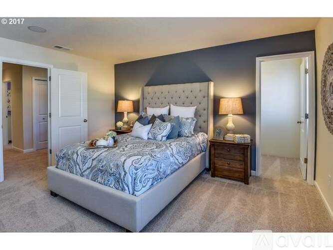 A bedroom with a large bed and a wooden nightstand.