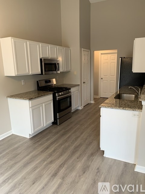 A kitchen with white cabinets and a granite countertop.