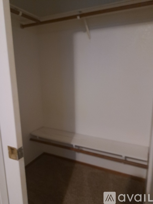 A small closet with a bench seat and a door.