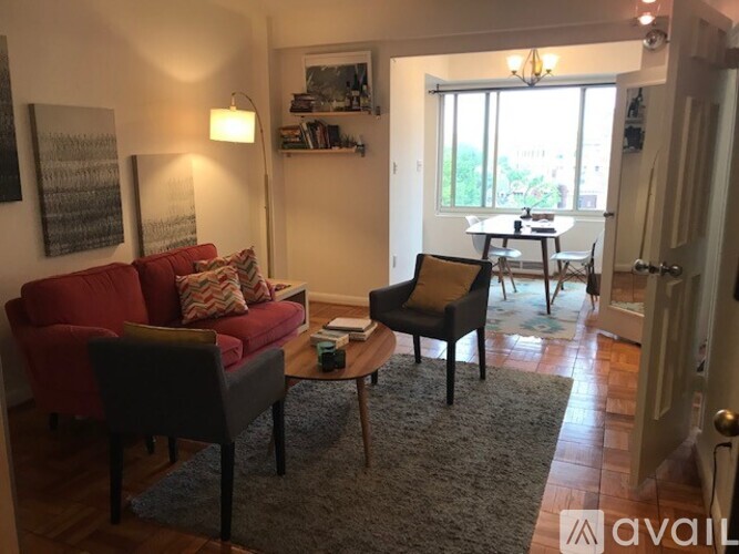 A living room with a red couch, a chair, and a coffee table.