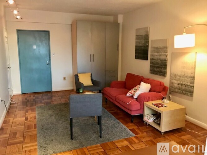 A living room with a red couch, grey chair, and a grey coffee table.