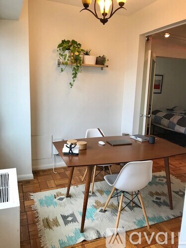 A dining room with a wooden table and white chairs.
