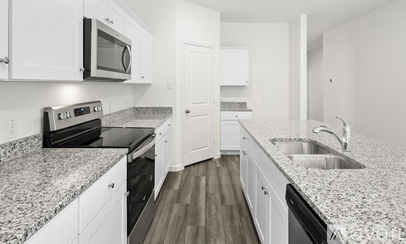 A kitchen with white cabinets and granite countertops.