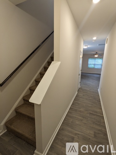 A hallway with a staircase and a window.