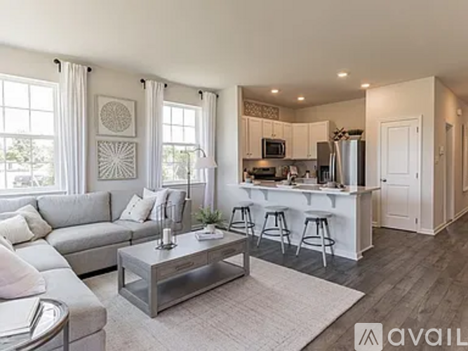 A modern living room with a bar area in the kitchen.