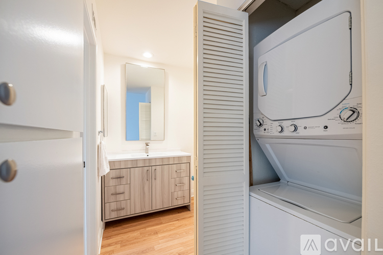A white washing machine is in a small laundry room.