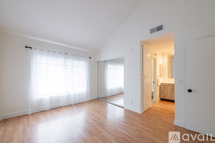 A spacious room with wooden floors and white walls.