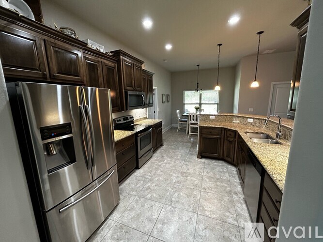 A kitchen with dark wood cabinets and stainless steel appliances.