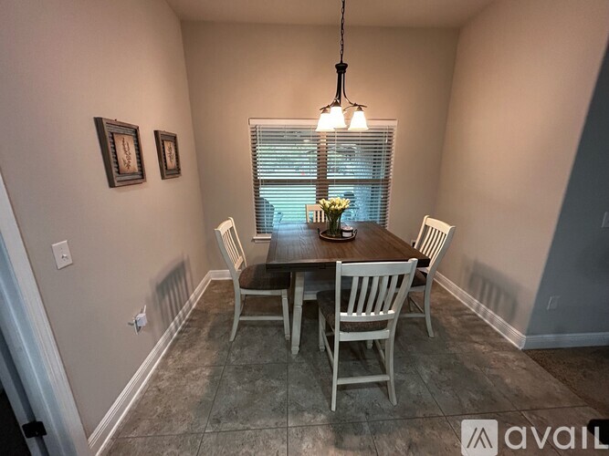 A dining room with a table and chairs.