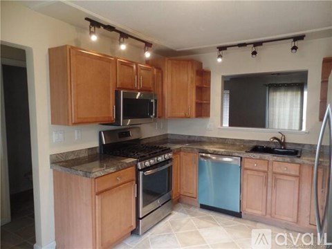 A kitchen with wooden cabinets and stainless steel appliances.