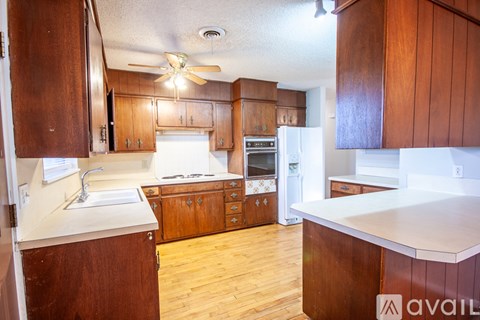 A kitchen with wooden cabinets and a white counter top.