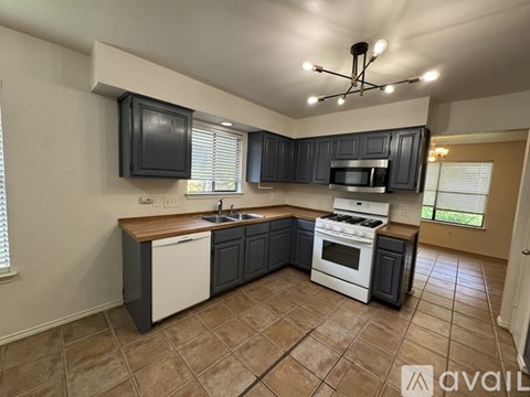 A kitchen with black cabinets and white appliances.