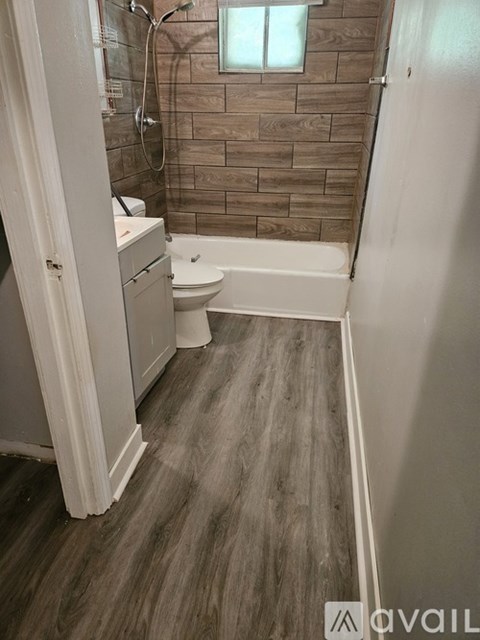 A bathroom with a toilet, sink, and bathtub.