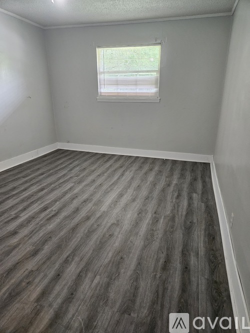 A room with a grey floor and a window.