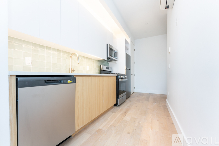 A kitchen with a stainless steel dishwasher and wooden cabinets.