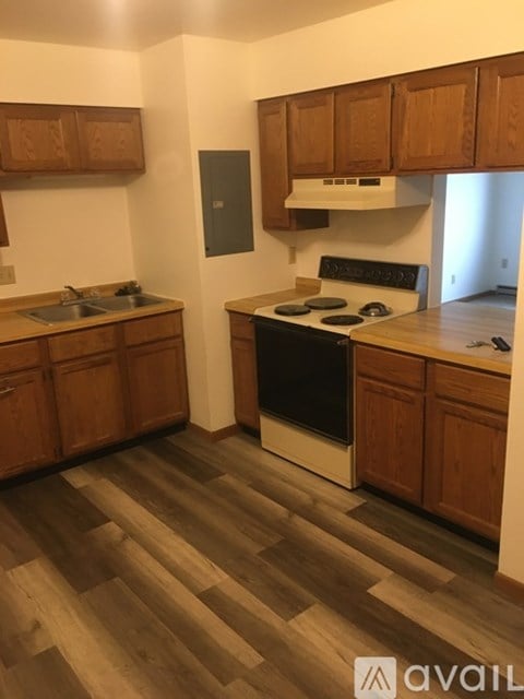 A kitchen with wooden cabinets and a black stove top oven.