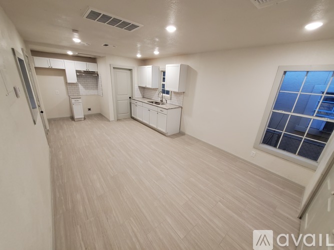 A spacious room with a window overlooking a building.