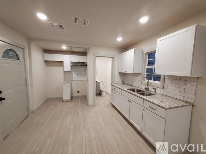 A kitchen with white cabinets and a sink.