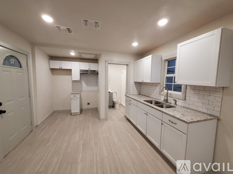 A kitchen with white cabinets and a sink.