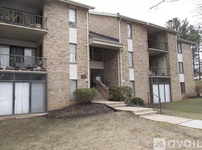 A brick apartment building with a balcony on the second floor.