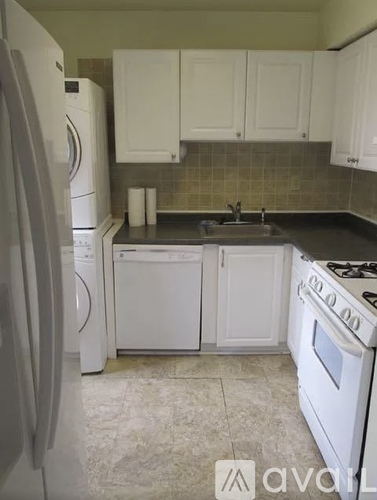 A kitchen with white appliances and cabinets.