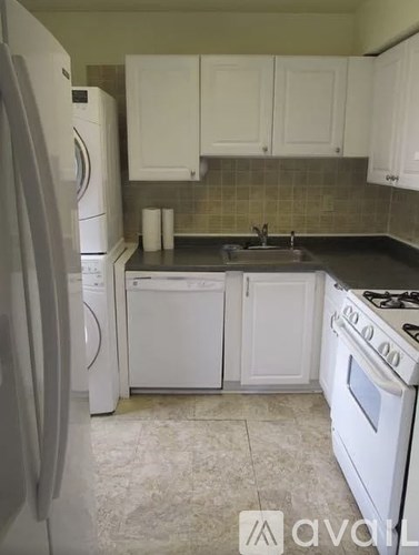 A kitchen with white appliances and cabinets.