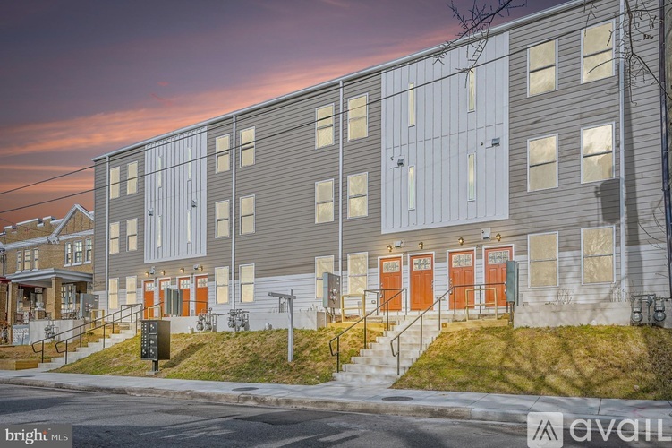 A building with grey walls and orange doors is shown.