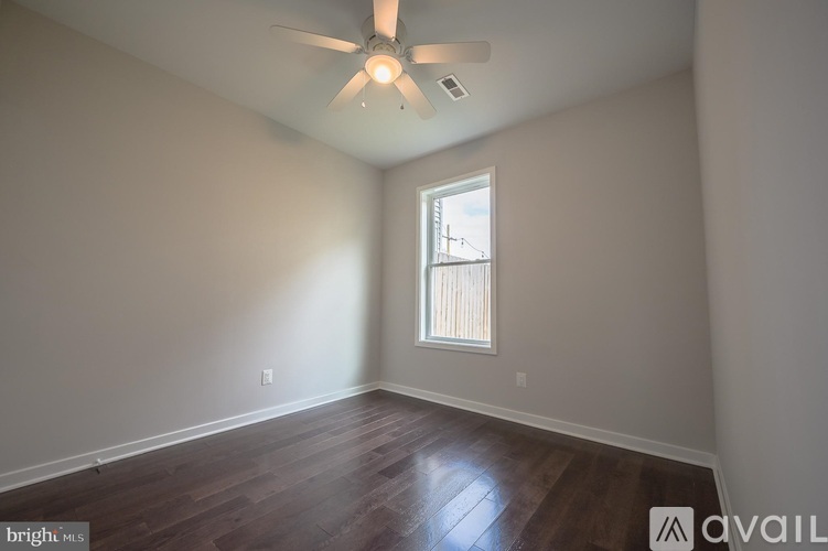 A room with a ceiling fan and a window.