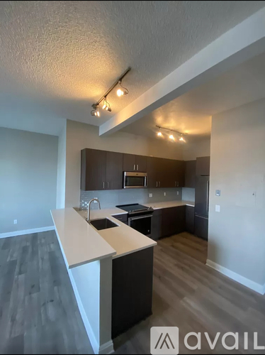 A kitchen with a white countertop and dark wood cabinets.