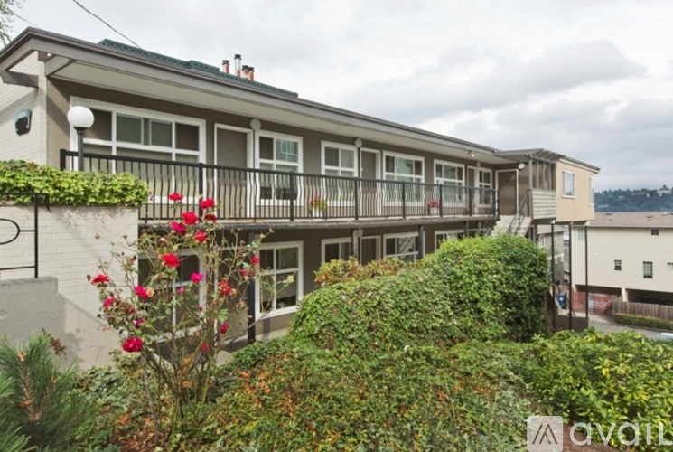 A building with a balcony and a garden in front.